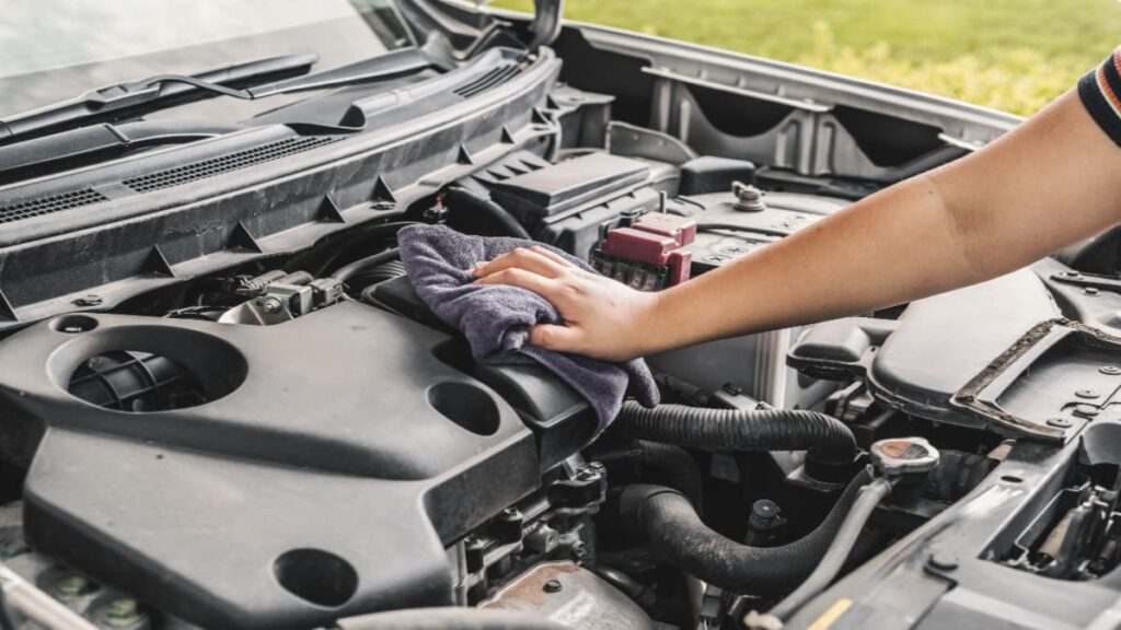 a man clean his car engine